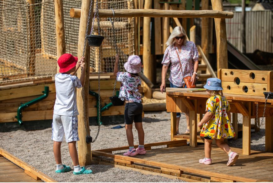 three children and an adult in a playground